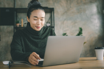 Workplace at home. A woman works on a laptop at home, sits on a disk in the living room during the day, Video call communication, Student use pc and internet e-learning remotely.