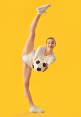 Beautiful cheerleader with soccer ball on color background