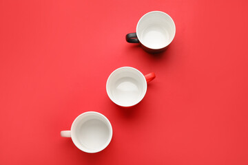 Empty cups on color background