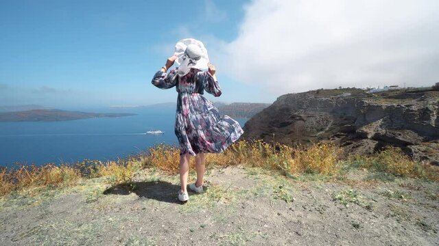 Elegant woman in dress enjoy caldera panoramic view of Santorini landscape