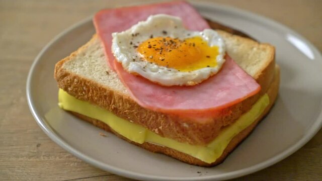 homemade bread toasted cheese topped ham and fried egg with pork sausage for breakfast
