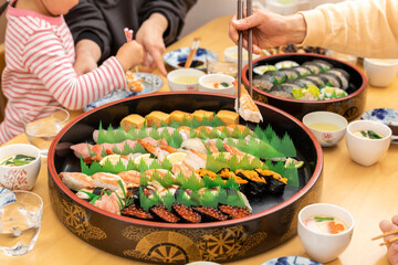 自宅で出前寿司を食べる家族