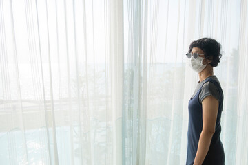 Asian female tourists wear gray clothes, glasses and face masks in State Quarantia.