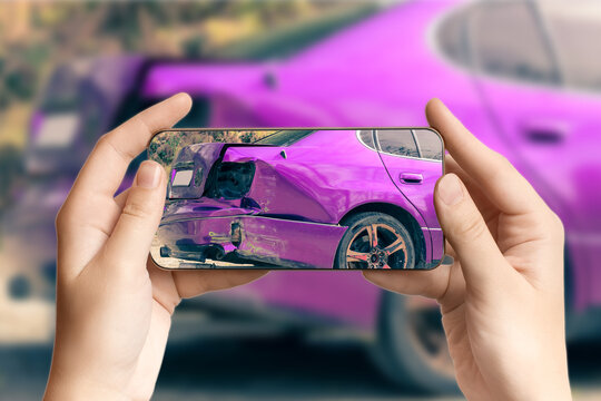 A girl takes pictures on a smartphone of car damage at the scene of an accident for insurance compensation. Selective focus.
