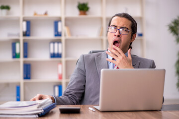 Fototapeta premium Young male employee sitting at workplace