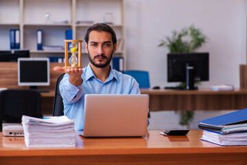 Young male employee in time management concept