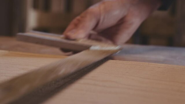 Carpenter In Workshop Using T-Square On Wood