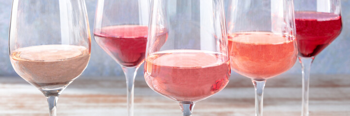 Rose wine panorama, various tints of pink wine, side view