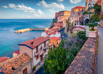 Naklejka na ściany i meble Amazing morning view of Scilla town with Ruffo castle on background, administratively part of the Metropolitan City of Reggio Calabria, Italy. Attractive summer seascape of Mediterranean sea.