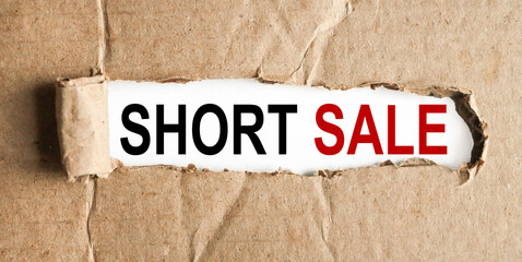 short sale. text on white paper over torn paper background.