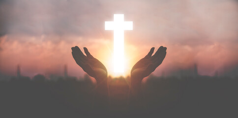 Silhouette a man use hand holding wooden cross with sunset backgrounds, religion concept,...