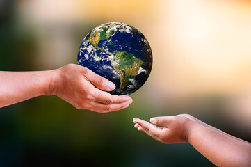 Father and daughter holding earth in hands on blur nature backgrounds. Earth day concept. Elements of this image furnished by NASA.