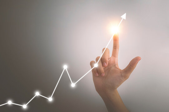 Investment and Economic growth concept, Hand pointing of businesswoman with financial symbols.