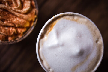 close-up of coffee with froth and dessert on the table top view