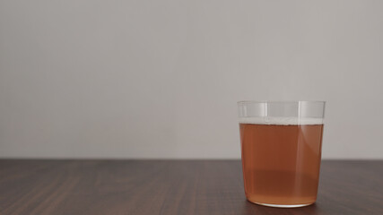 orange drink in tumbler glass on walnut table with copy space