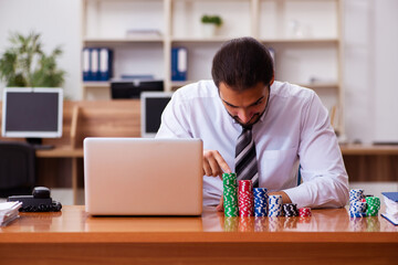 Young male employee in gambling concept