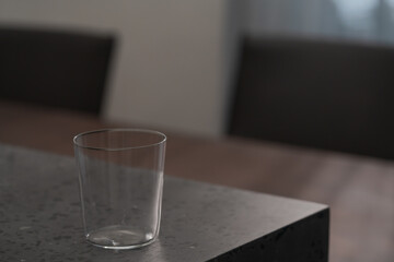 thin tumbler glass on concrete countertop with copy space