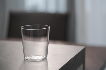 thin tumbler glass on concrete countertop with copy space