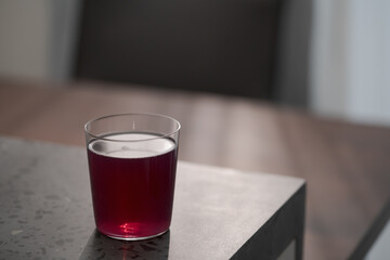 purple drink in tumbler glass on concrete countertop with copy space