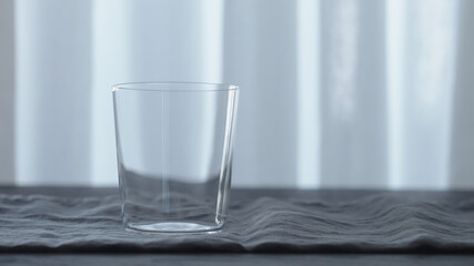 thin tumbler glass on linen cloth with copy space