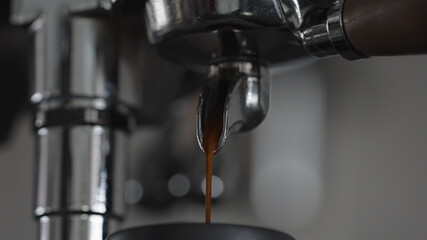 espresso pour from single spout portafilter into black cup