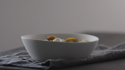 put kumato tomatoes on fettuccine in white bowl on linen cloth