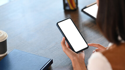 Close up view of young female office worker using smart phone in office.