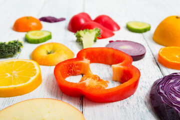 sliced fruit and vegetable circles on white wood table