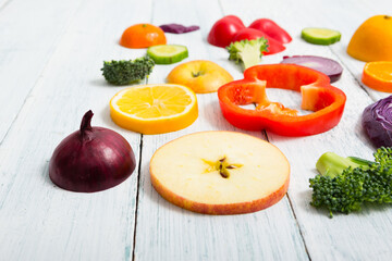 sliced fruit and vegetable circles on white wood table