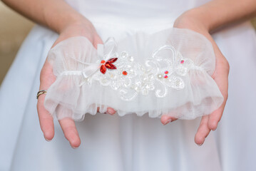 Bride in a white dress is holding a beautiful bright bridal bouquet.
