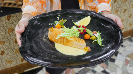 Close up Silician salmon. salmon healthy diet with added fresh vegetables and lemon wedges