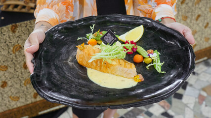 Close up Silician salmon. salmon healthy diet with added fresh vegetables and lemon wedges