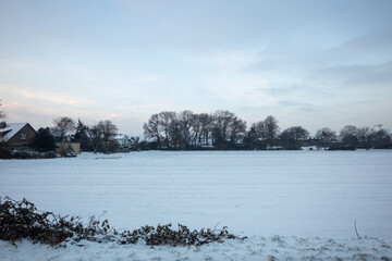 Naklejka premium Outdoor scenery of snow cover field in small town countryside in winter season in Europe.