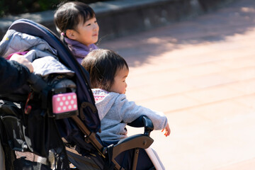 ベビーカーに乗った幼児とお姉ちゃん