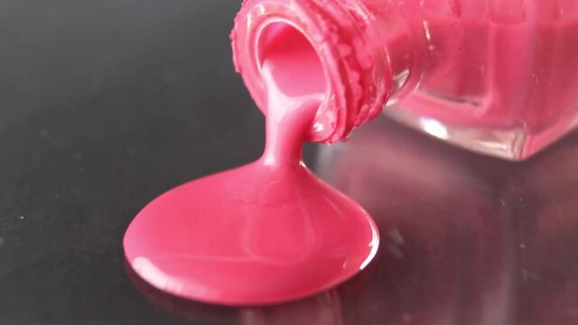 pink nail polish drips from bottle bottle on black background beauty nail service