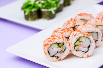Maki Sushi - Roll made of smoked salmon and cream cheese. Traditional Japanese cuisine concept, over purple background.