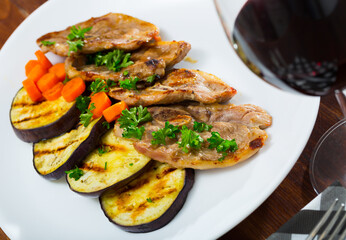 Juicy slices of mutton with grilled eggplant and carrot on plate