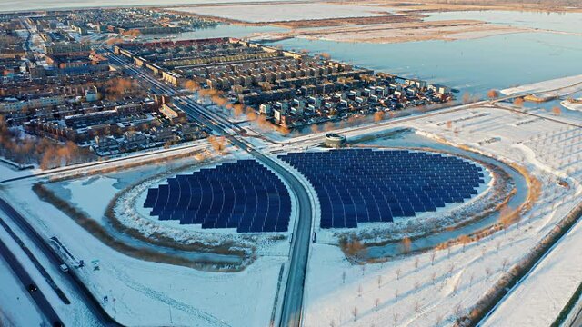 Solar panels farm in a modern sustainable residential neighbourhood in the city of Almere, The Netherlands (Amsterdam suburb) in winter. Aerial shot. 