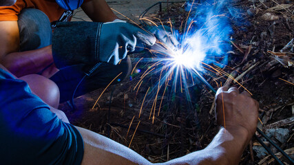 Industrial workers at a close-up welding plant