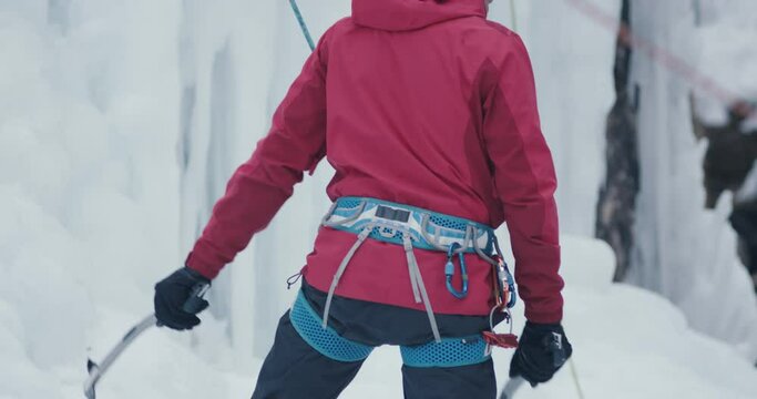 Man take axe hammer start climb frozen ice extreme sports in winter