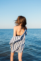 Girl in a striped shirt on the background of the sea.