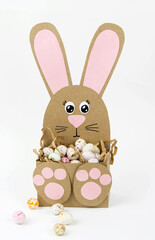 Crafts with children for Easter from colored paper. Boxes bunnies for sweets in the form of eggs. Flat lay.