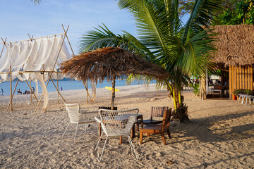 Beach chairs and umbrella made of straw and bamboo at beautiful tropical sea beach