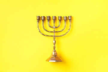 Golden hanukkah menorah on yellow background. Jewish holiday banner with copy space. Ancient ritual...