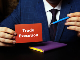 A handsome businessman showing a blank piece of paper with sign Trade Execution . Close-up shot....