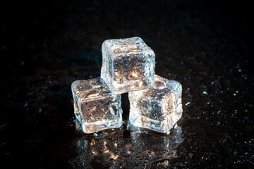 ice cubes reflection on black table background.