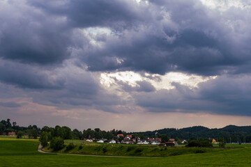 Fototapeta na wymiar gloomy thunderclouds over a rural area with meadows and forest in the Baden Allgäu near Wolfegg