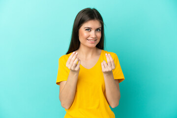 Obraz premium Young caucasian woman isolated on blue background making money gesture