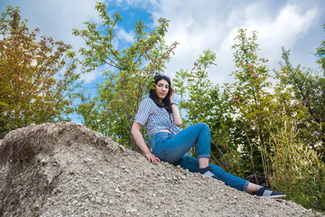 Naklejka na ściany i meble prety woman sit in sand in quarry. enjoy time in summer vacation