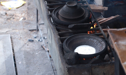 the process of cooking pancakes serabi in a traditional way using wood